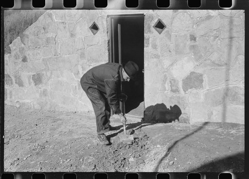 Mr. S. Castle or Mr. William S. Allen working in front of new storage house he built on their farm with FSA (Farm Security Administration) help. Southern Appalachian project, near Barbourville, Knox County, Kentucky. Mr. William S. Allen cleaning up yard in front of his new storage house, Southern A