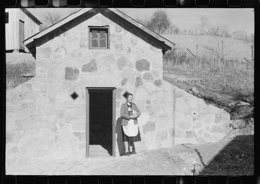 Untitled photo, possibly related to: Mrs. S. Castle or Mrs. William S. Allen with canned goods in front of new storage house her husband built on their farm with FSA (Farm Security Administration) help. Southern Appalachian project, near Barbourville, Knox County, Kentucky