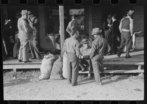 Untitled photo, possibly related to: Spanish trappers and fur buyers waiting around while muskrats are being graded during auction sale on porch of community store, St. Bernard, Louisiana