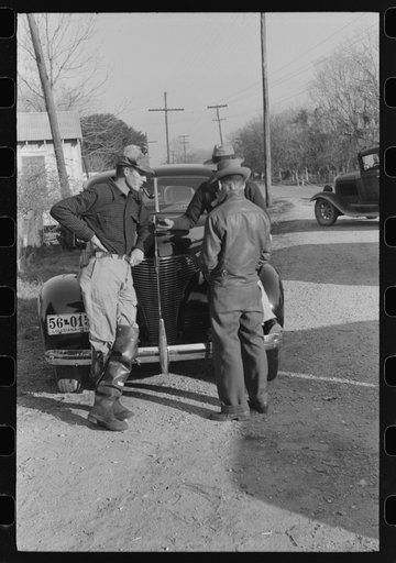 Spanish trappers and fur buyers waiting around while muskrats are being graded during auction sale on porch of community store, St. Bernard, Louisiana