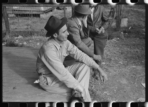 Spanish trappers and fur buyers waiting around while muskrats are being graded during auction sale on porch of community store, St. Bernard, Louisiana