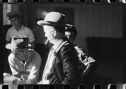 Fur buyers and trappers waiting for FSA (Farm Security Administration) supervisor to open the bids at auction sale of muskrats in dancehall on Delacroix Island, Louisiana. See general caption no. 1