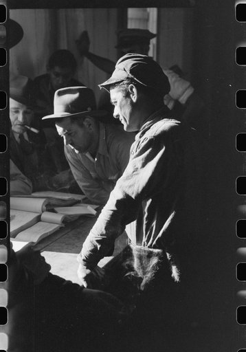 Fur buyers and trappers waiting for FSA (Farm Security Administration) supervisor to open the bids at auction sale of muskrats in dancehall on Delacroix Island, Louisiana. See general caption no. 1