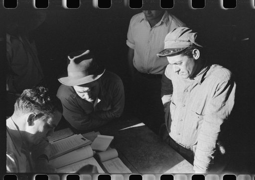 Fur buyers and trappers waiting for FSA (Farm Security Administration) supervisor to open the bids at auction sale of muskrats in dancehall on Delacroix Island, Louisiana. See general caption no. 1
