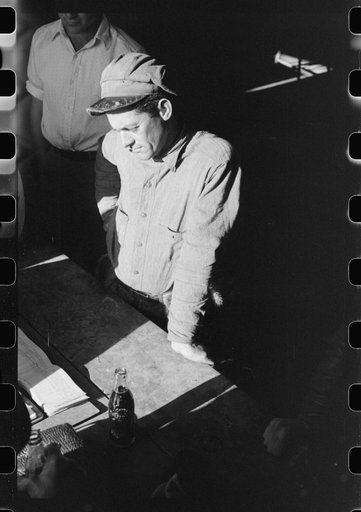 Spanish trapper waiting for FSA (Farm Security Administration) supervisor to open the bids on the next "lot" of muskrats to be sold at auction held in dancehall on Delacroix Island, Louisiana