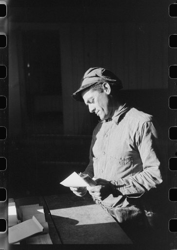 Spanish trapper looking at receipt which FSA (Farm Security Administration) supervisor has just given him for making payment on his loan. He has just sold a "lot" of muskrats at auction sale held in dancehall on Delacroix Island, Louisiana