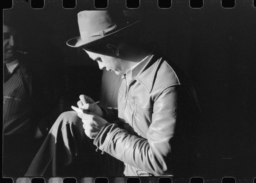 Untitled photo, possibly related to: Spanish fur buyer figuring out his bid on the next lot of muskrats at auction sale held in dancehall on Delacroix Island, Louisiana. See general caption no. 1