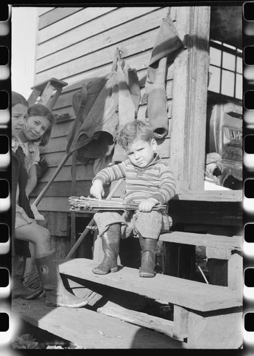 Untitled photo, possibly related to: Spanish muskrat trapper's son with stretched skins in his hands. In back of their camp in the marshes on Delacroix Island, Louisiana. See general caption no. 1