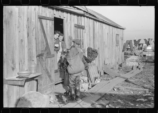 Untitled photo, possibly related to: Spanish trapper's family looking in his bag at his "catch" of muskrats. In front of their camp in the marshes near Delacroix Island, Louisiana. See general caption no. 1