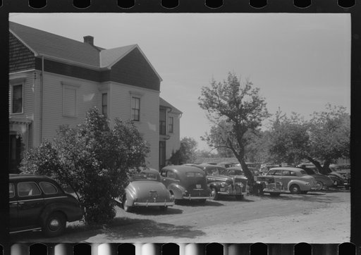 Cars parked in yard of private home across from Pratt and Whitney, United Aircraft. They charge fifty cents a week or ten cents a day. They have about 400 cars every twenty-four hours. East Hartford, Connecticut