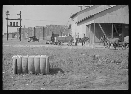 Untitled photo, possibly related to: At the cotton gin. Cotton gin and wagons. Hale County, Alabama