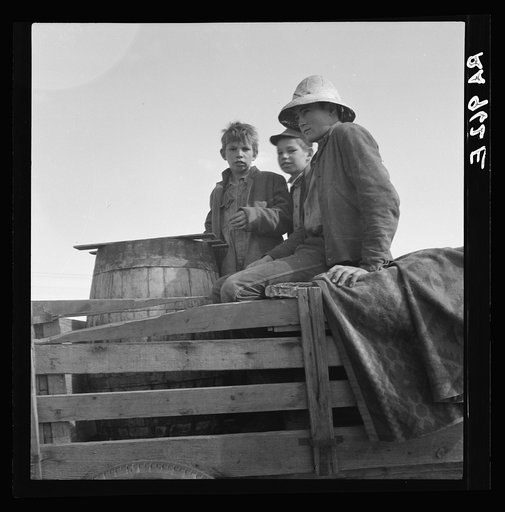 On location of Resettlement Administration film near Bakersfield, California. Three brothers, drought refugees from Texas (note water barrel)