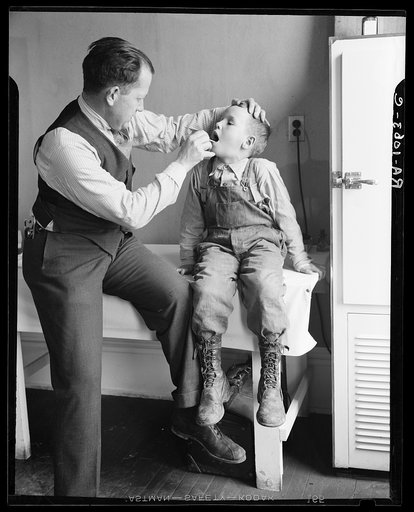 Doctor examining boy's throat. Reedsville, West Virginia
