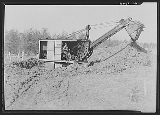 Mechanical digger working on cellar foundation at one of the housing units at the Berwyn project, Maryland