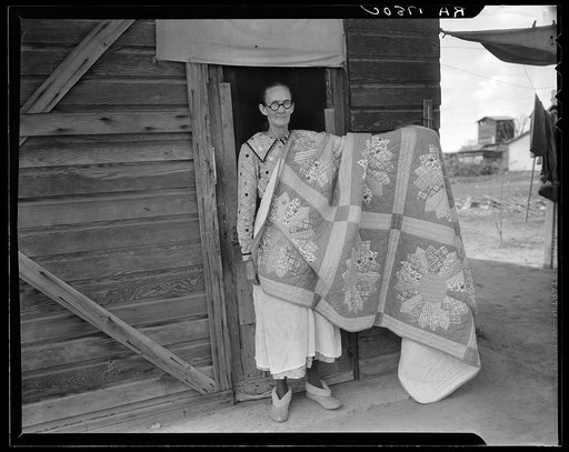Grandmother from Oklahoma and her pieced quilt. California, Kern County