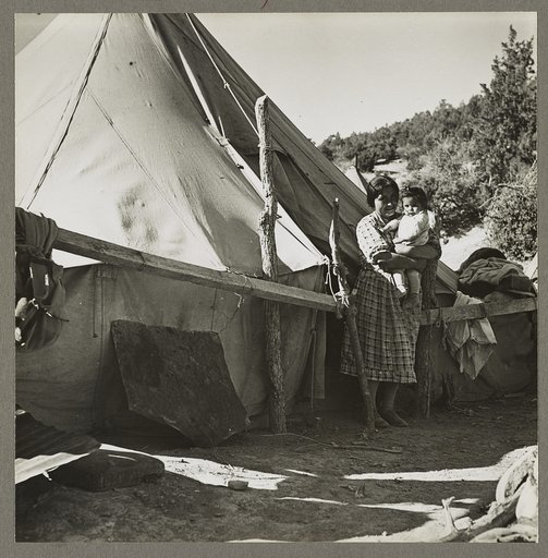 An Indian woman in front of her tepee. Many Indians on the Mescalero Reservation in New Mexico live in such primitive tents