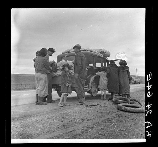 Migrants, family of Mexicans, on road with tire trouble. Looking for work in the peas. California