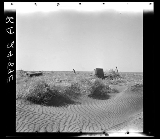 Fence almost completely buried under drifts of soil. Near Liberal, Kansas