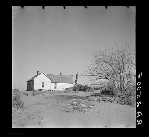 Shifting drifts of dust will soon force this farmer to abandon his home near Liberal, Kansas