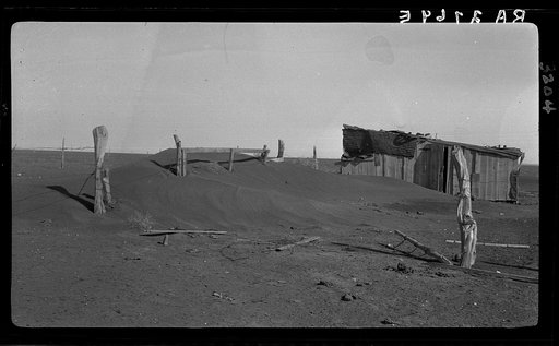 Fence corner and outbuilding being buried by dust. Misuse of lands is the chief cause of results such as this. Mills, New Mexico