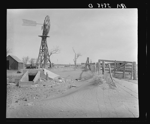 Drifting soil in a farmyard. Hartley County, Texas