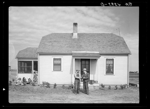 Farmer receiving check from or giving check to project manager. Falls City Farmsteads, Nebraska