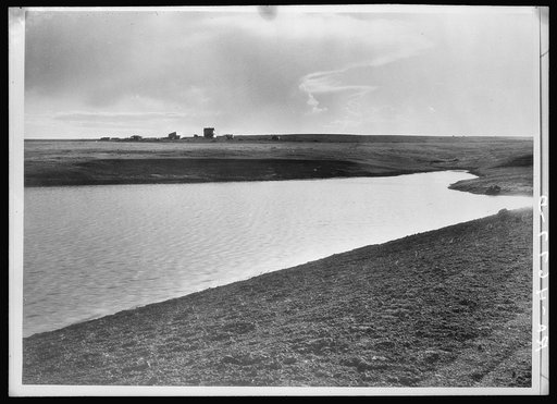 Completed stock water dam which will benefit ranch in background. Pennington County, South Dakota