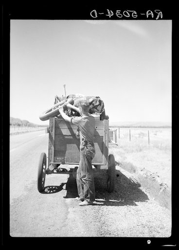 Drought refugees from South Dakota on highway making sure that nothing falls off the trailer to the Pacific Coast. Montana