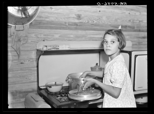 While father and mother are both at work in the citrus packing plant this little girl keeps house. Winterhaven, Florida