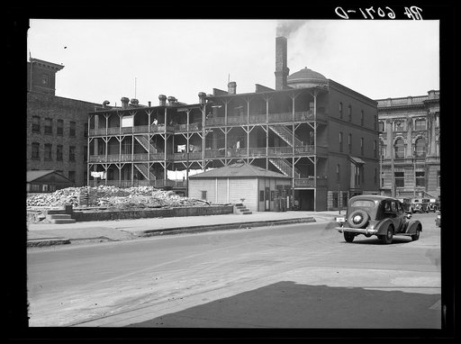 Rear of apartments at 8th and Wisconsin, with Milwaukee Public Library in background. Milwaukee, Wisconsin