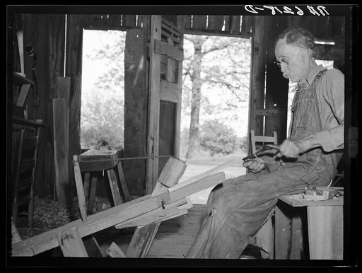 William Stamper, age eighty two, shaving oak sticks for chair braces in his workshop. Lake of the Ozarks passover area, Missouri