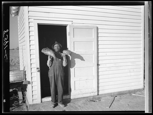Project farmer in front of smokehouse. Roanoke Farms, North Carolina