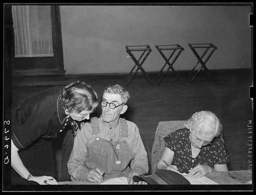 Home supervisor helping farm couple at group meeting. York, Nebraska