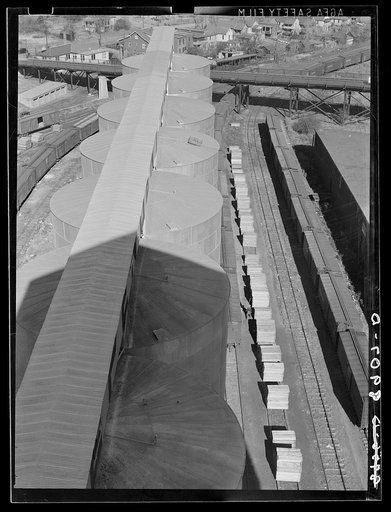 Tops of grain elevators, stacks of lumber, freight cars. Omaha, Nebraska