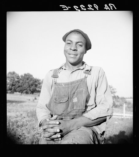 Plough boy sitting on fence after a day's work. Eutaw, Alabama