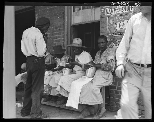 Lunchtime for these Georgia peach pickers. They earn seventy-five cents a day in the orchards. Muscella, Georgia
