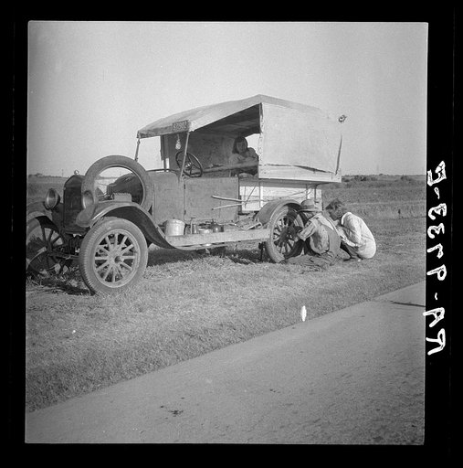 Family between Dallas and Austin, Texas. The people have left their home and connections in South Texas, and hope to reach the Arkansas Delta for work in the cotton fields. Penniless people. No food and three gallons of gas in the tank. Father is trying to repair a tire. Three children. Father says,