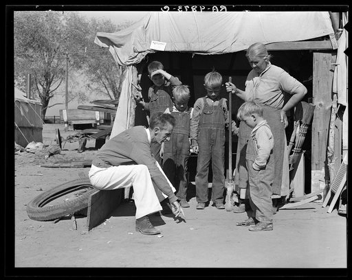 Tom Collins, manager of Kern migrant camp talking with drought refugee and her four sons. California