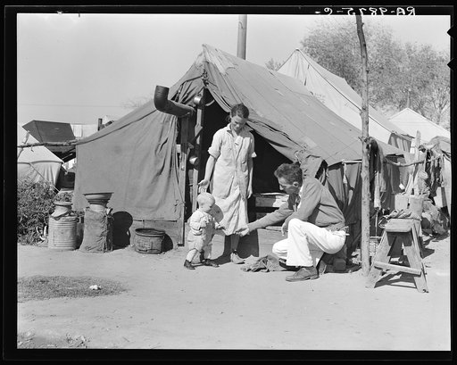 Tom Collins, manager of Kern migrant camp, with drought refugee family. California