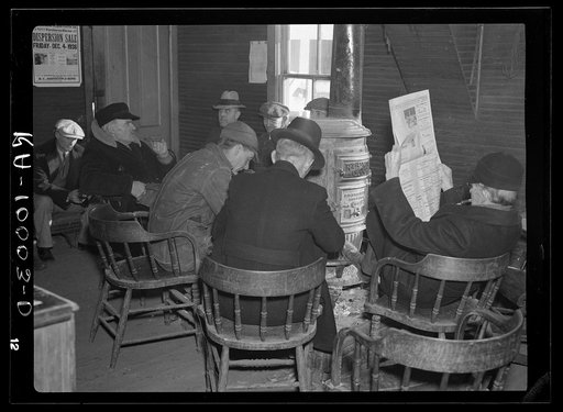 Weighing-in room of the stockyards. Aledo, Illinois. Farmers sitting around the stove enjoying themselves and getting warm. The stove is still a middle western institution