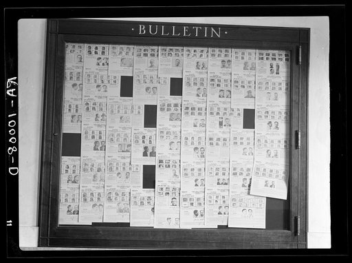 Bulletin board in post office showing a large collection of "wanted men." Ames, Iowa