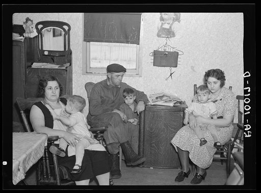 Part of the L.H. Nissen family of ten living in a three-room shack. Rest of family at school. The whole house was of unusually high humidity. The wife said they could not dry out the bedding because of the poor ventilation. This is the living room and kitchen combined. Iowa