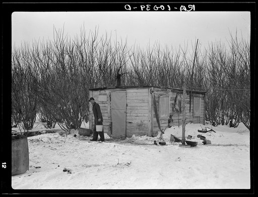 William Helmke in front of his one-room shack built by himself. Ninety acre farm, crop share lease owned by lawyer. Iowa