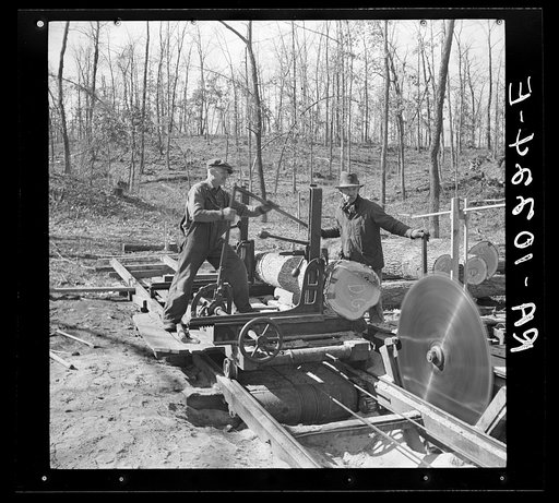 Setting the fresh log in position to be sawed. Country sawmill near Omaha, Illinois