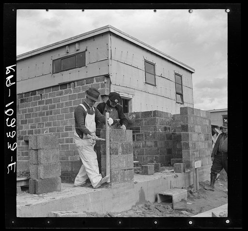 Houses under construction at the Greenhills project. Using the level to lay cinder blocks. Ohio