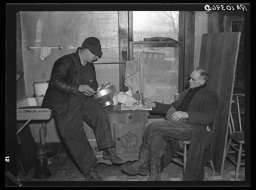 Settling up after the closing-out sale on Frank Sheroan's farm near Montmonenci, Indiana. Mr. Sheroan is shown with the clerk of the sale