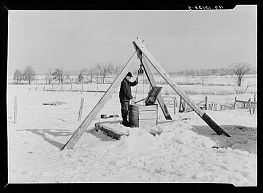 Oscar Gaither, tenant farmer, near McLeansboro, Illinois, hoisting water from his well