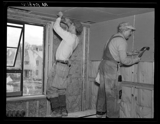 Installing wallboard in a house at the Greenhills project, Ohio. Note sound proofing and insulation
