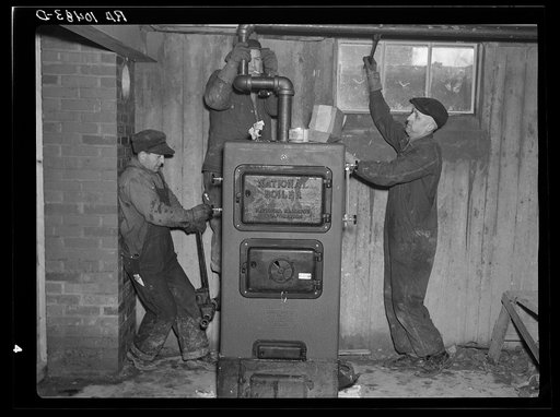 Plumbers at work in the basement of a house on the Greenhills project, Ohio