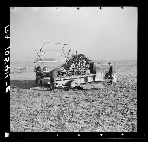Binder loaded on a truck, preparatory to moving it. The rear wheels of the truck were lowered by digging pits to facilitate loading the binder. Raymond Zink, tenant farmer, is moving from one farm to another twenty-four miles away. Near Templeton, Indiana